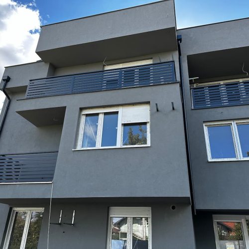 Ograde za terasu sa sivim horizontalnim linijama na spratnoj kući