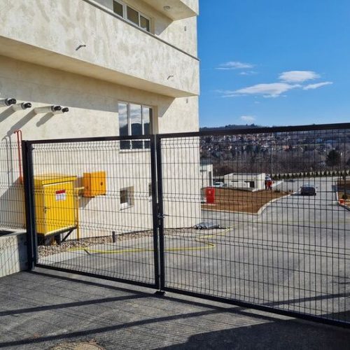 anelne kapije dvokrilne sa mrežastim panelima na ulazu u gradilište pored objekta