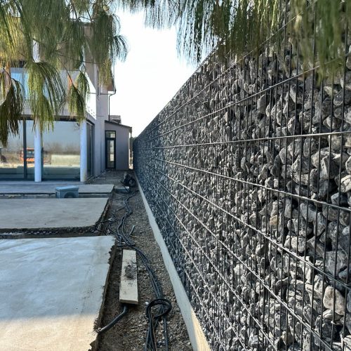 Linearna gabionska ograda uz prilaz i uređenu betonsku stazu