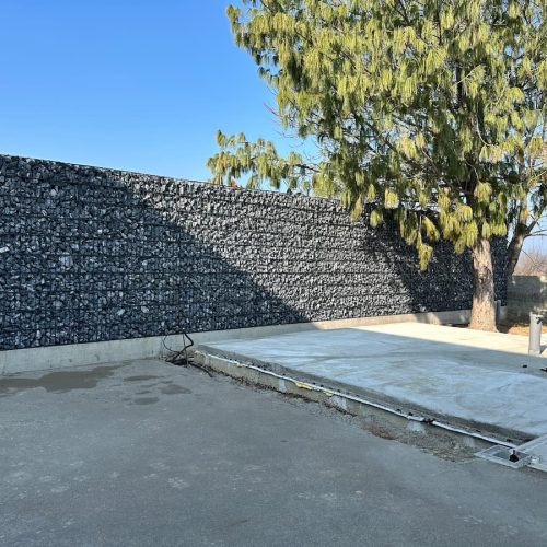 Gabioni potporni zid velike dužine uz betonsku površinu dvorišta