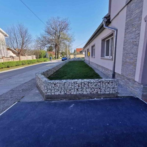 Gabioni potporni zid uz kuću sa kamenim punjenjem i uredjenim prilazom