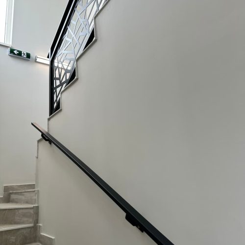 Unutrašnja ograda za stepenice sa CNC panelima i zidnim rukohvatom, čista linija i stabilna metalna konstrukcija